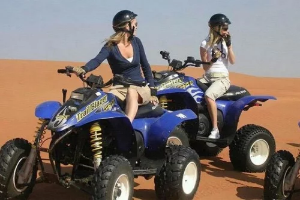 tourists enjoying quad biking in the deep desert of ras al khaimah, with sand surfing on quad bike tour ras al khaimah